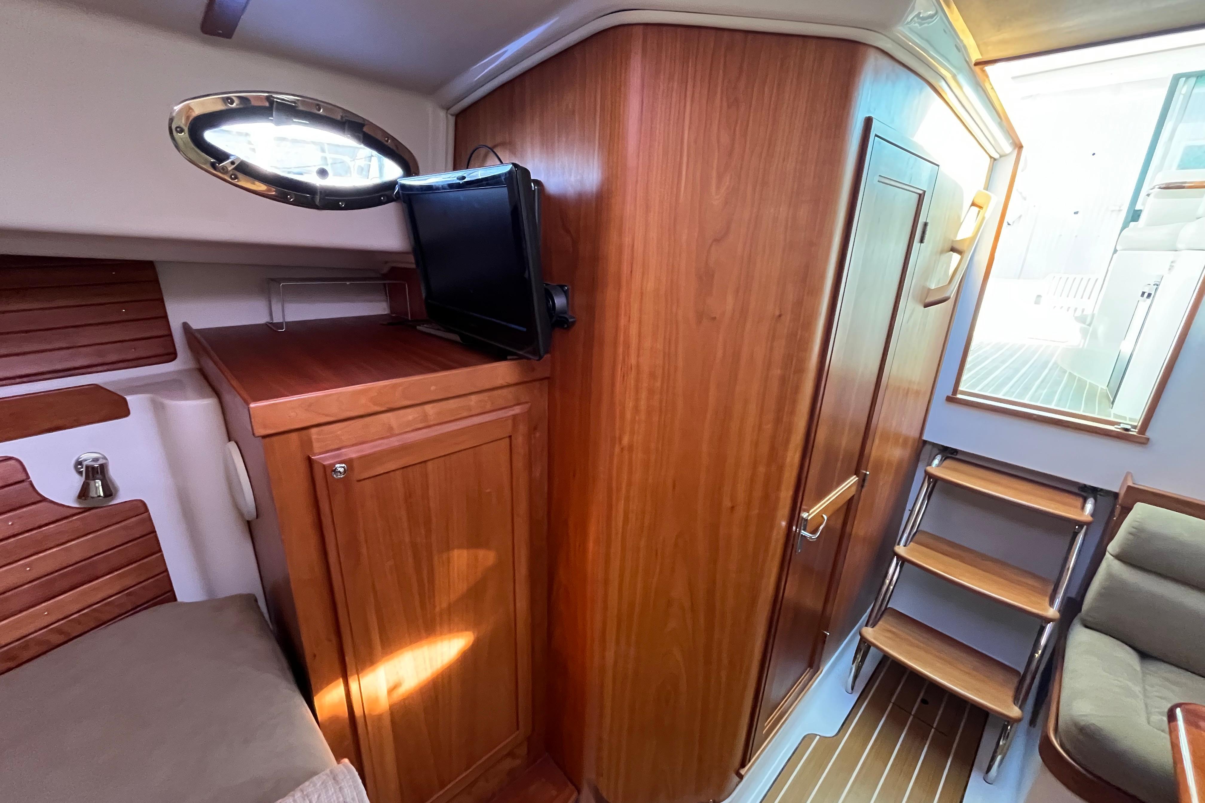 2010 Back Cove 33 Express Hardtop interior with wood cabinetry and compact TV.