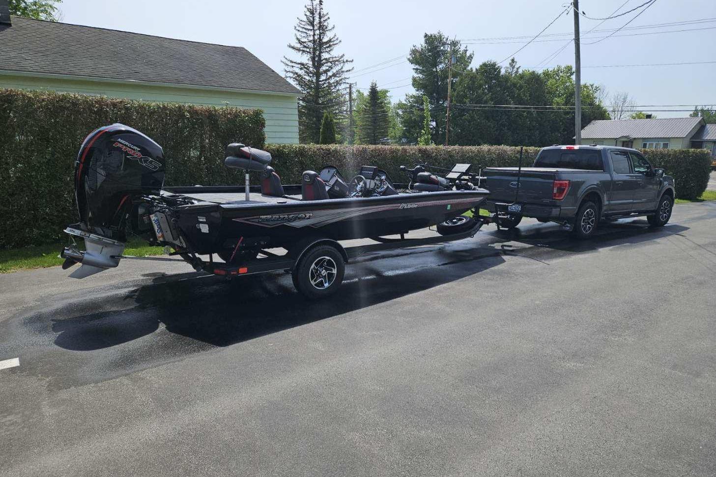 2022 Ranger RT198P Fishing Package boat hitched to a pickup truck in a driveway.