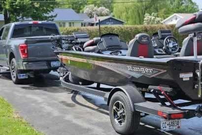 2022 Ranger RT198P Fishing Package on trailer, hitched to a truck, parked outdoors.