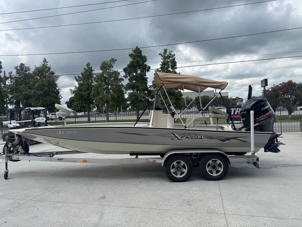 2013 Xpress Hyper-Lift Bay Series H22B boat on trailer, parked outdoors.