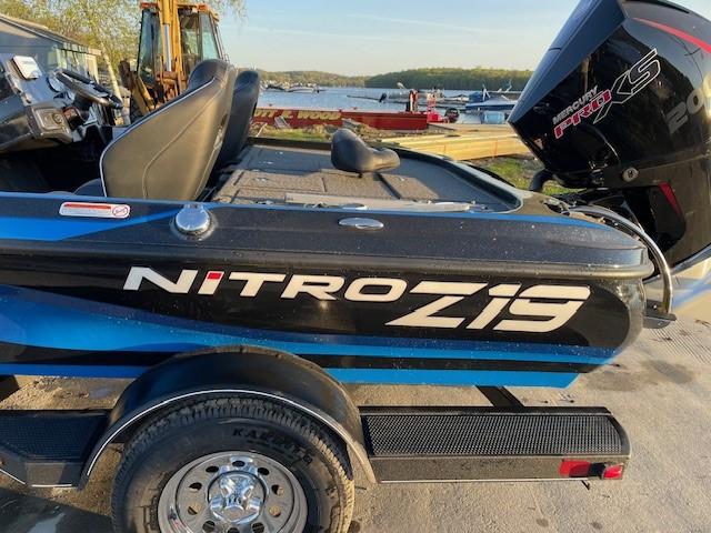 2024 Nitro Z19 boat on trailer near lake.