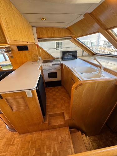 Interior of 1991 Ocean Alexander 46 yacht kitchen with wood cabinetry and modern appliances.