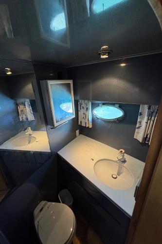 Bathroom interior of 1991 Ocean Alexander 46 yacht with porthole and modern fixtures.