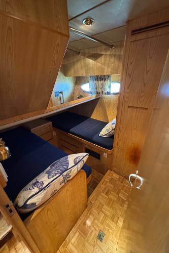 Cozy cabin interior of 1991 Ocean Alexander 46 yacht with wooden finish and twin beds.