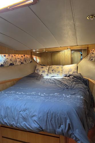 Cozy bedroom in 1991 Ocean Alexander 46 yacht with floral decor and wood paneling.
