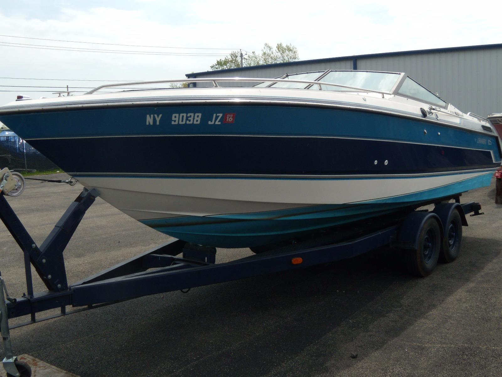 1989 Chaparral 2300 SX Sport boat on trailer, blue and white exterior.