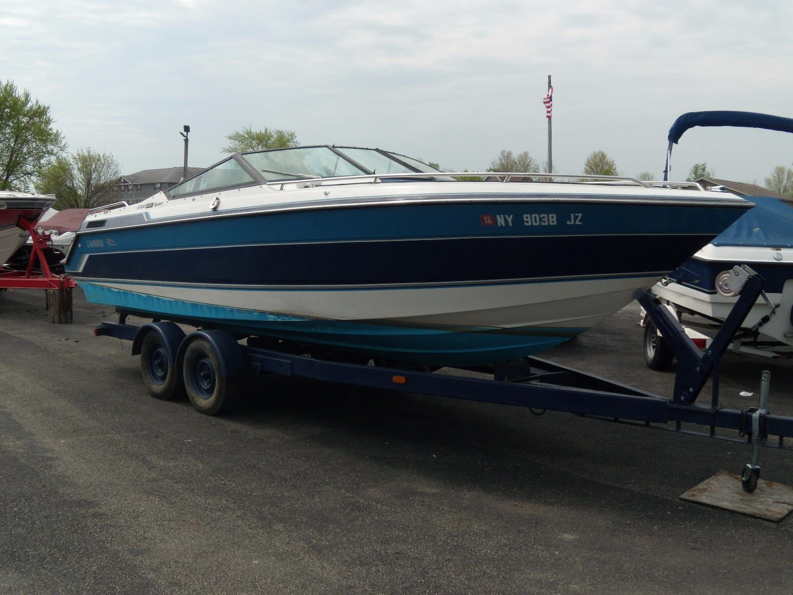 1989 Chaparral 2300 SX Sport boat on trailer, parked outdoors.