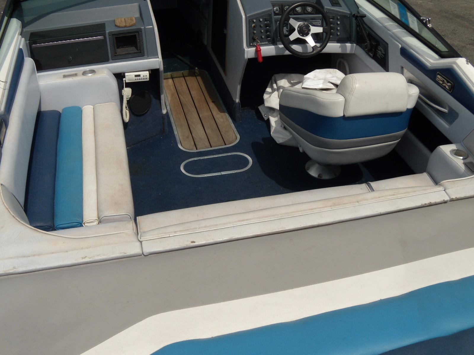 1989 Chaparral 2300 SX Sport boat interior with blue and white seating and steering console.