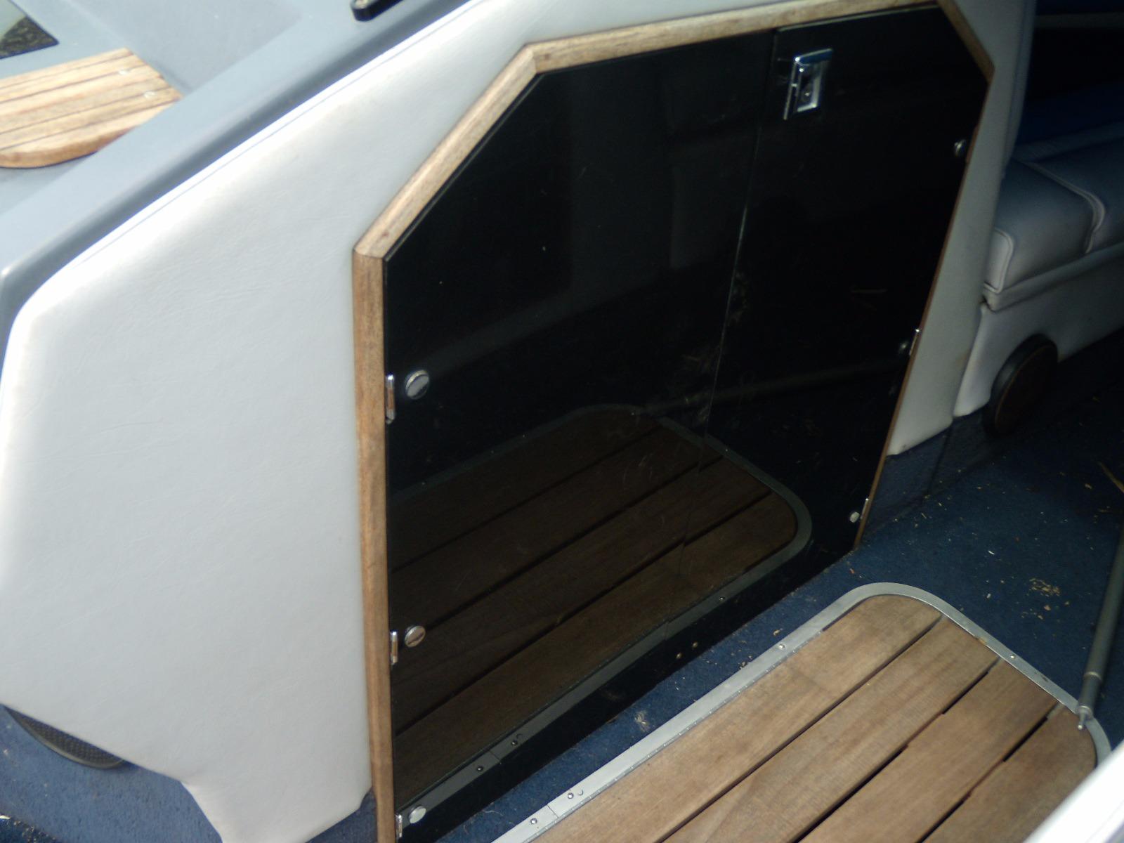 1989 Chaparral 2300 SX Sport boat interior with wooden accents and black panel door.