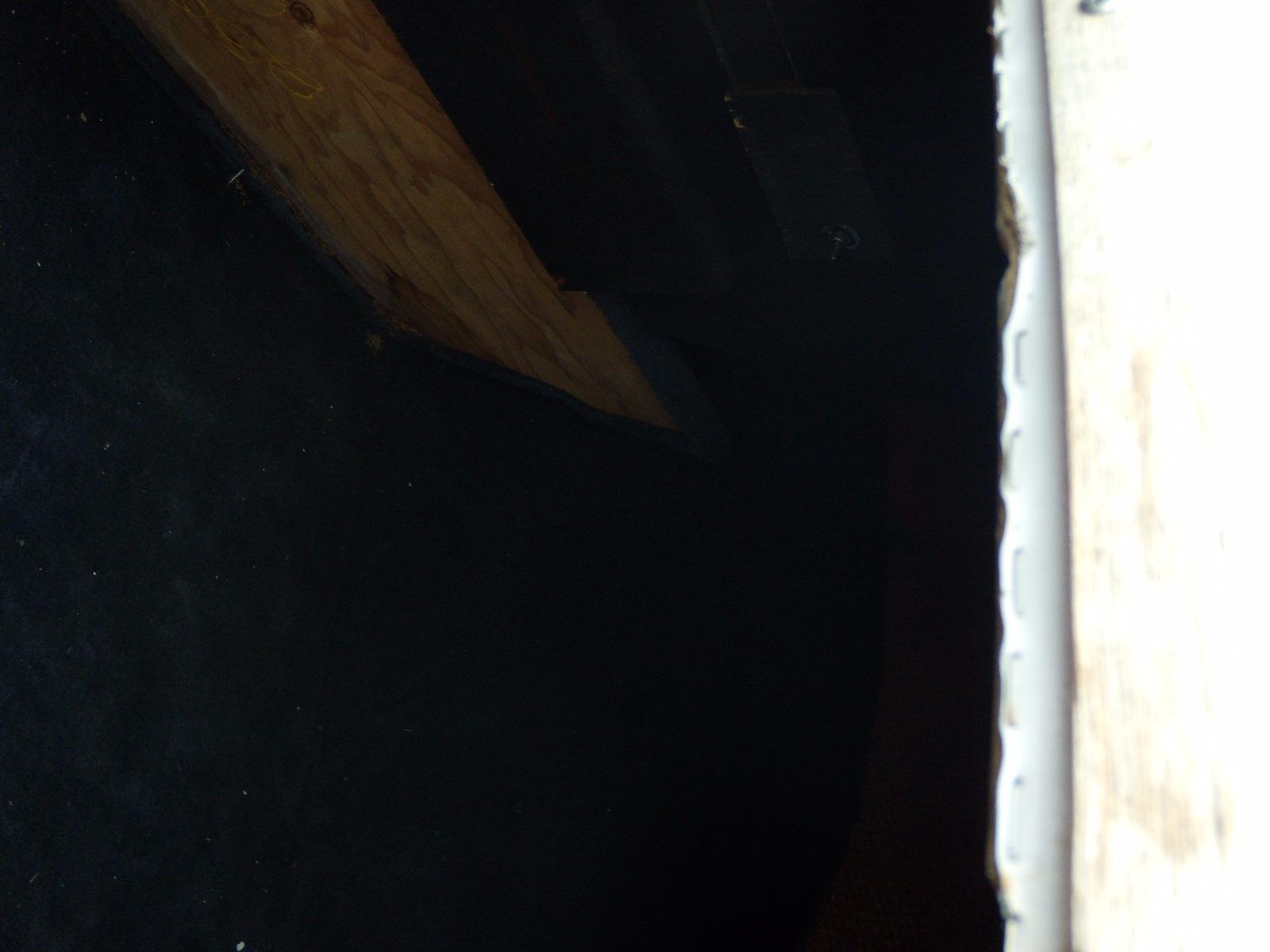 Dark interior of a 1989 Chaparral 2300 SX Sport boat, featuring wood and carpet elements.