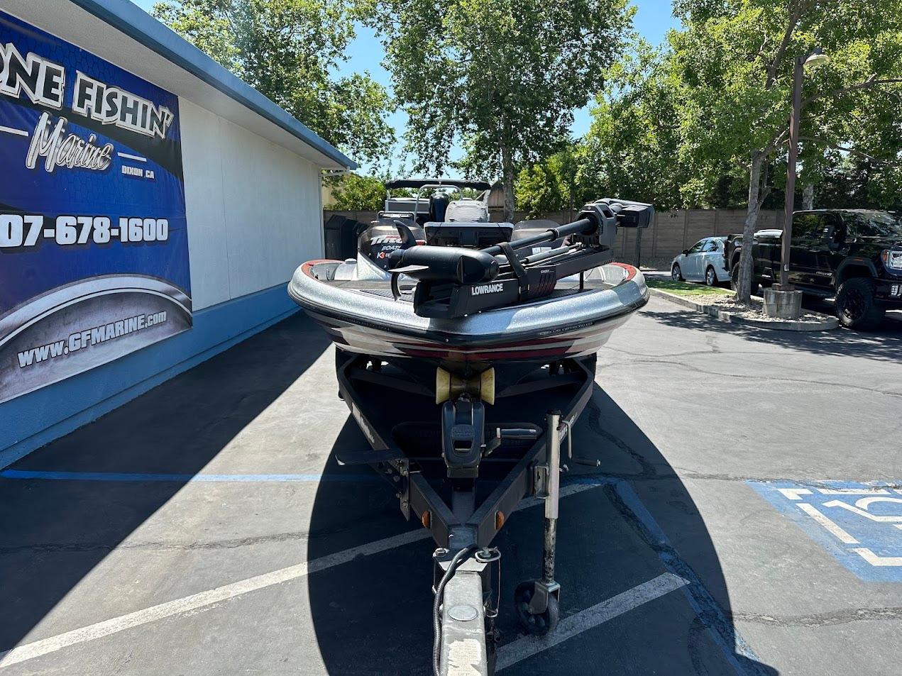 2013 Triton 19XS boat on trailer in parking lot, near marine store.