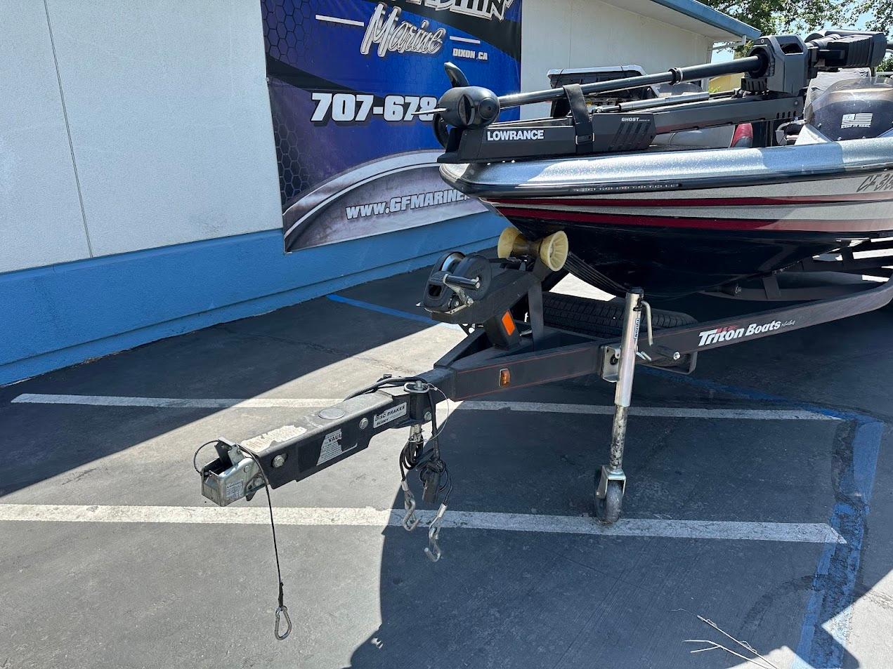 2013 Triton 19XS boat on trailer, parked outdoors, featuring Lowrance equipment.