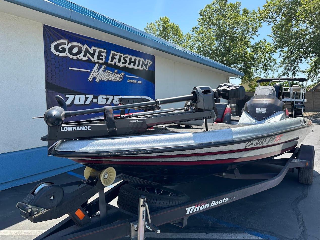 2013 Triton 19XS boat on trailer, parked outside Gone Fishin' Marine store.