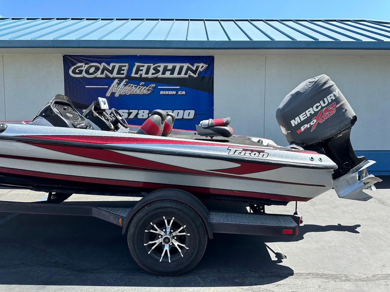 2013 Triton 19XS boat with Mercury Pro XS engine on trailer, parked outside dealership.