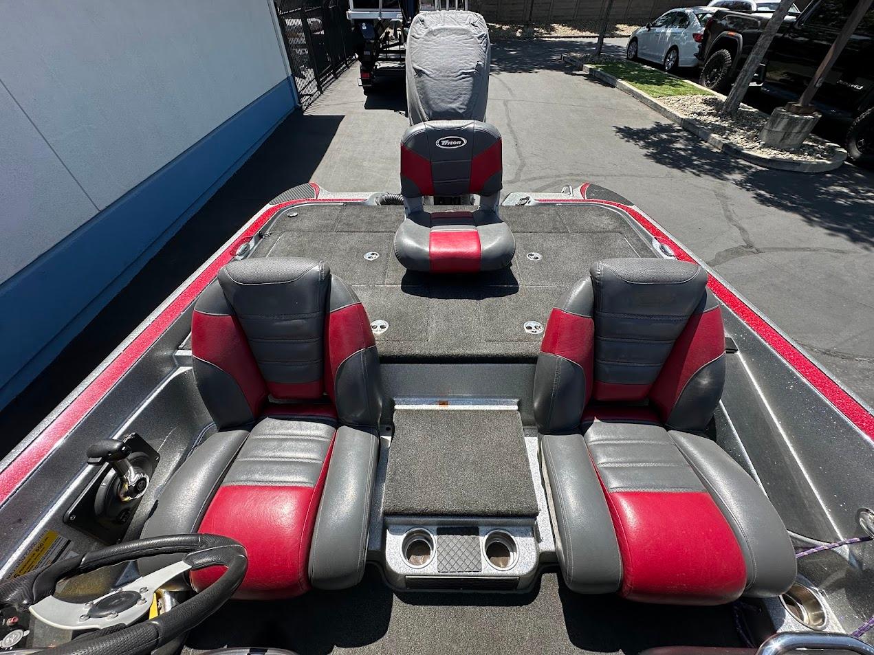 2013 Triton 19XS boat interior with red and gray seats, steering wheel, and cup holders.