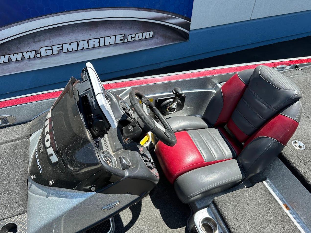 2013 Triton 19XS boat cockpit with red and gray seating, steering wheel, and control panel.