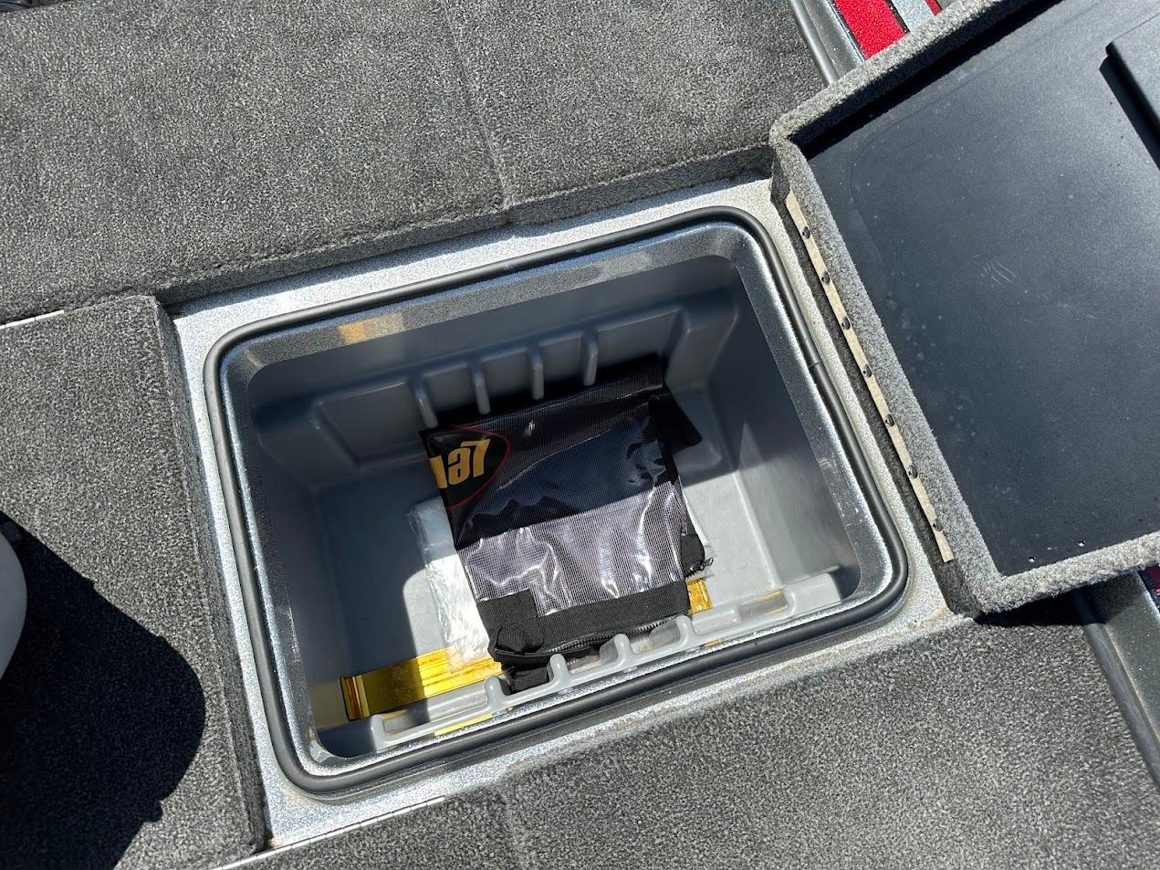 Storage compartment in a 2013 Triton 19XS boat, featuring a neatly organized interior.