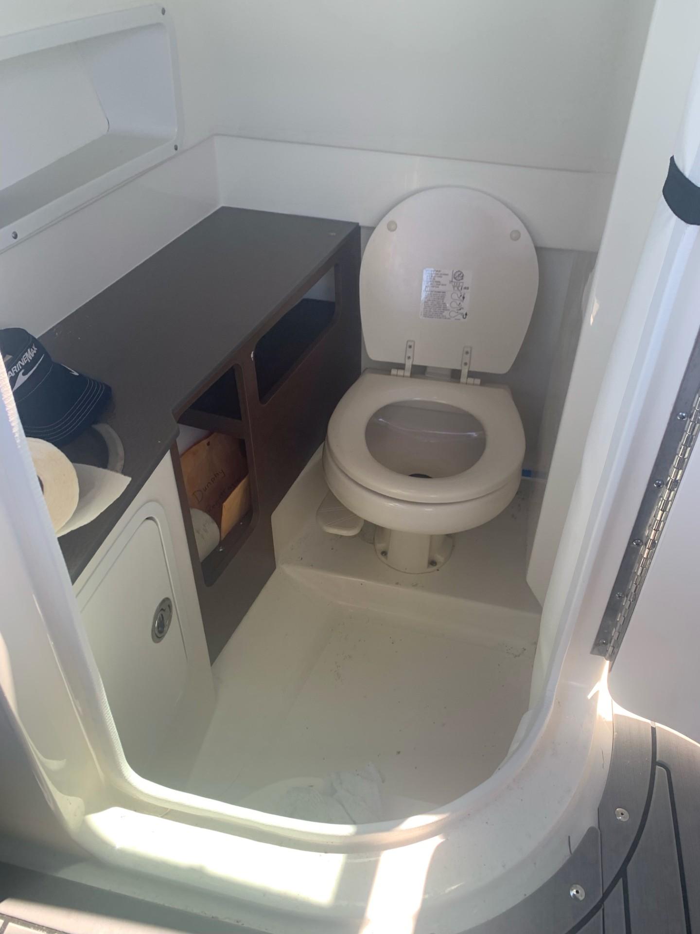 2021 Sea Ray SDX 270 Outboard boat interior with toilet and storage area.