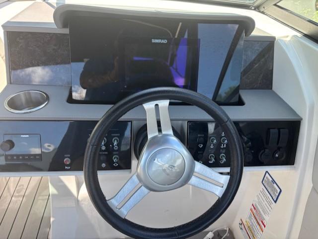 Steering wheel and dashboard of 2021 Sea Ray SDX 270 Outboard boat.