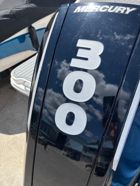 Mercury 300 outboard engine on 2021 Sea Ray SDX 270 boat, reflecting sky and clouds.