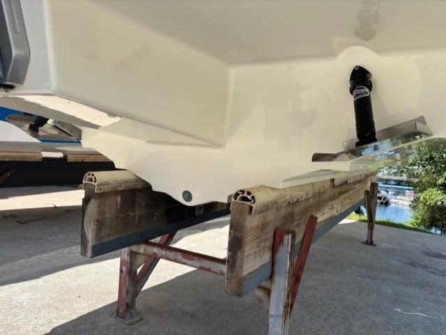 2021 Sea Ray SDX 270 Outboard boat hull on a wooden stand.