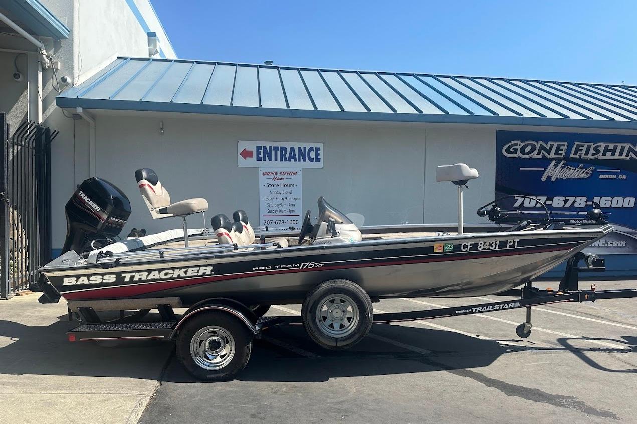 2001 Bass Tracker Pro Team 175 boat on trailer outside a fishing store.