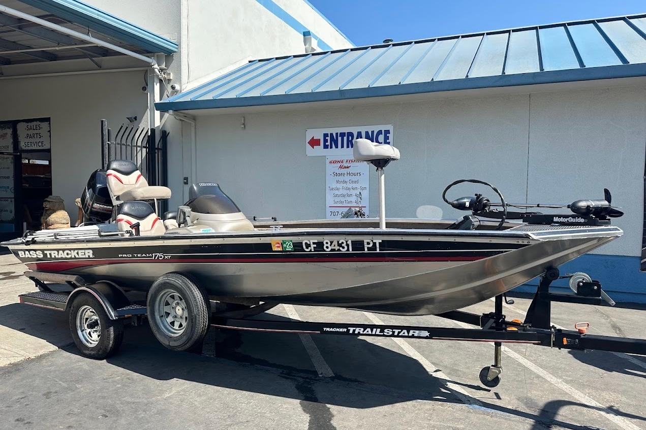 2001 Bass Tracker Pro Team 175 boat on trailer, parked outside a service center.