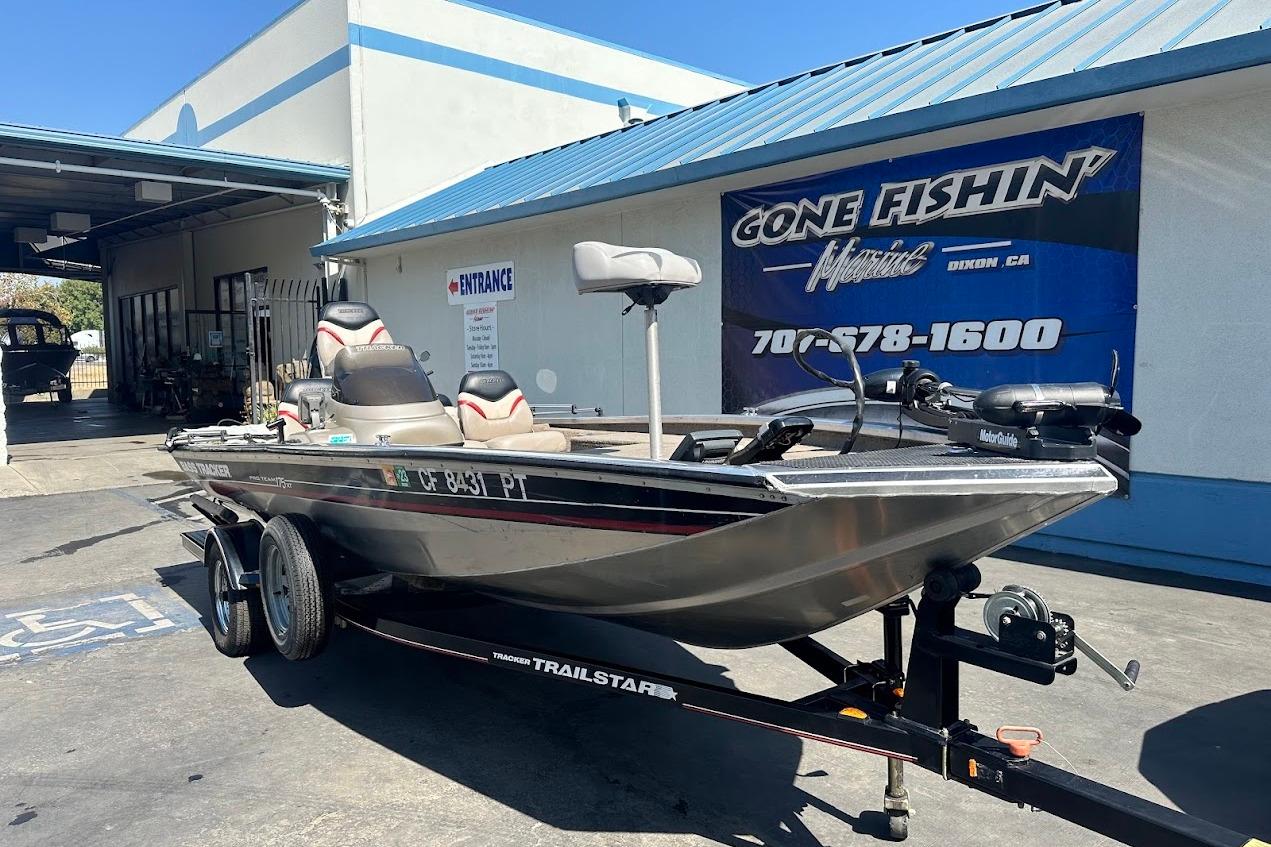 2001 Bass Tracker Pro Team 175 boat on trailer outside marine shop.