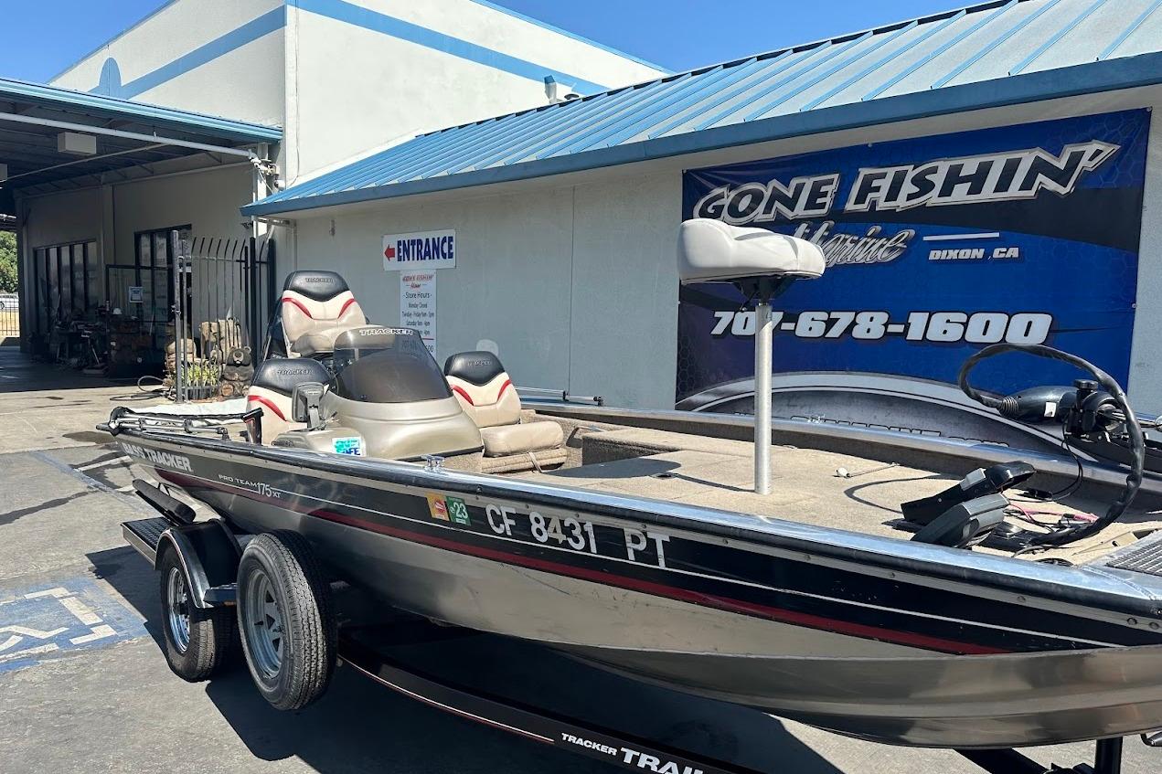 2001 Bass Tracker Pro Team 175 boat parked outside a fishing store.