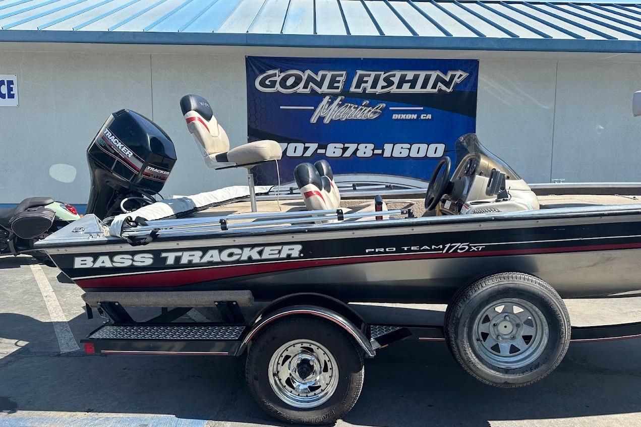 2001 Bass Tracker Pro Team 175 boat on trailer, parked outside a marine store.