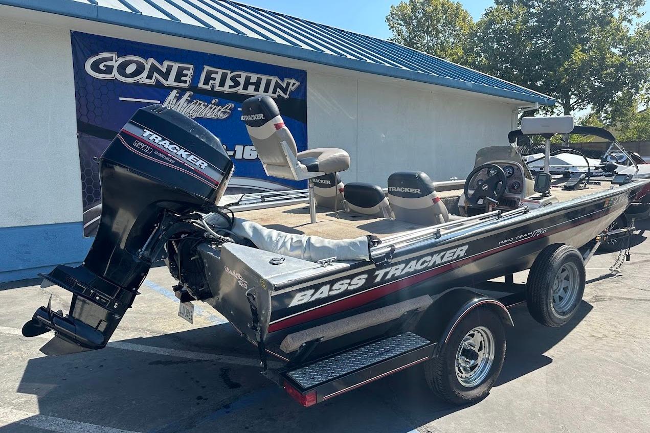 2001 Bass Tracker Pro Team 175 boat parked at a dealership, featuring a Tracker outboard motor.