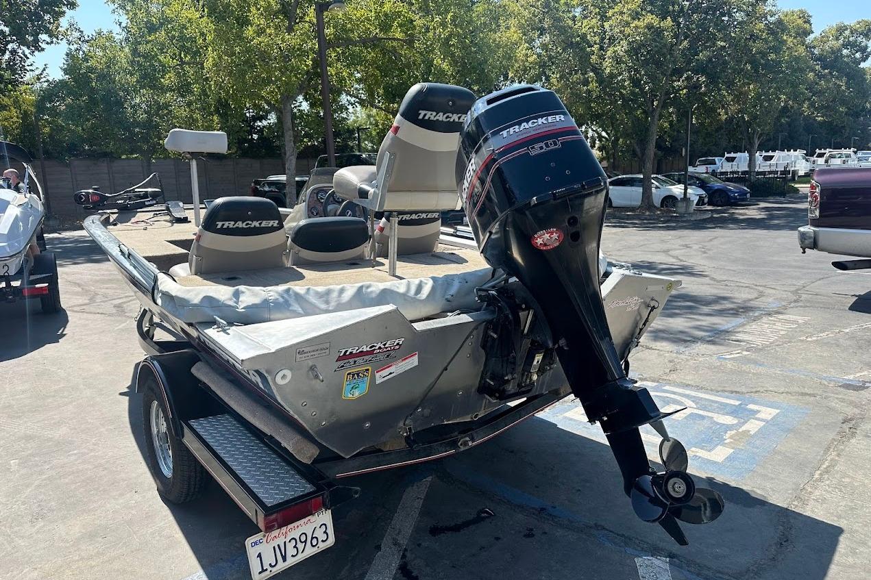 2001 Bass Tracker Pro Team 175 boat with outboard motor in parking lot.