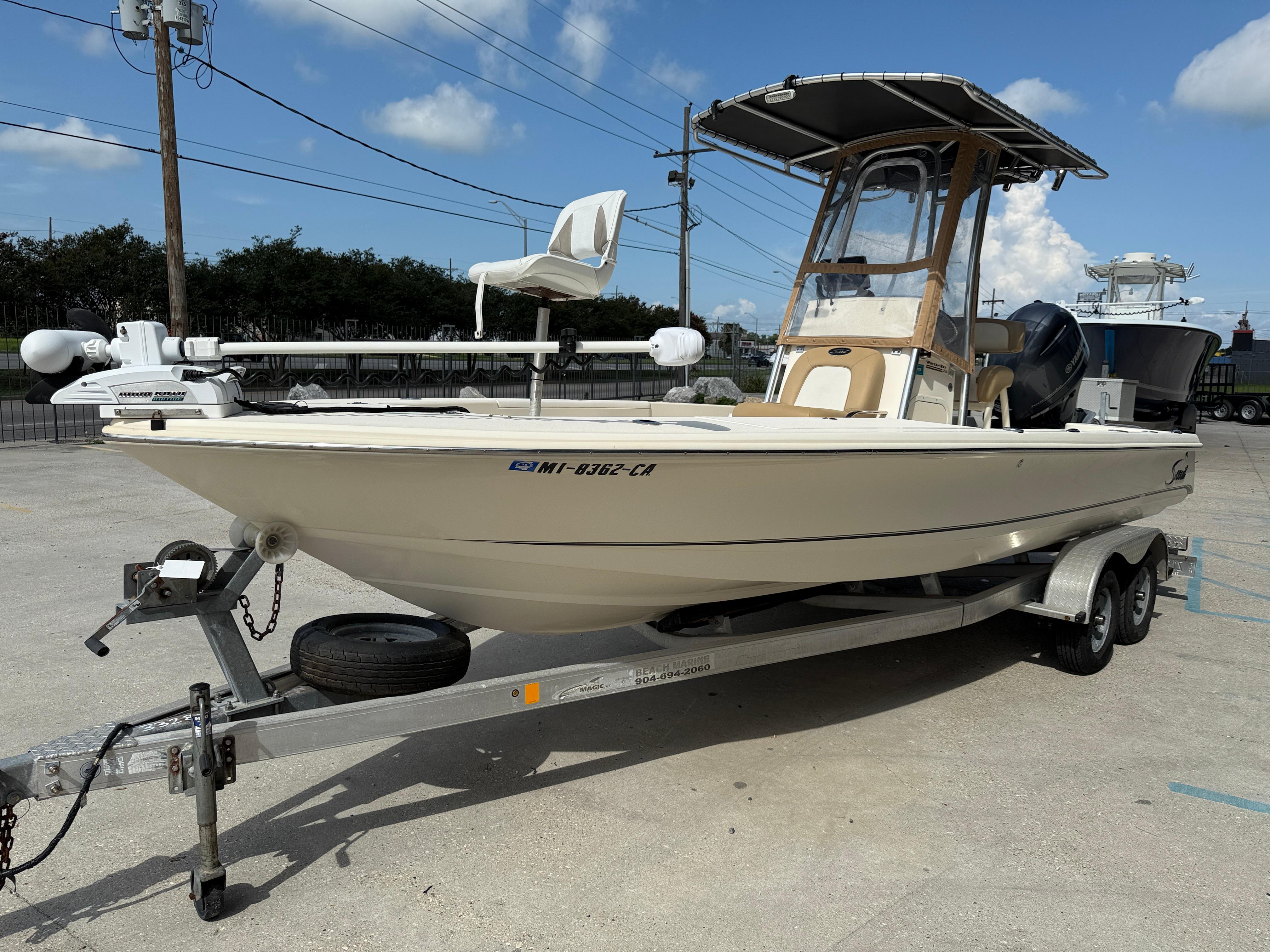 2014 Scout WINYAH BAY 221 boat on trailer, parked outdoors under clear sky.