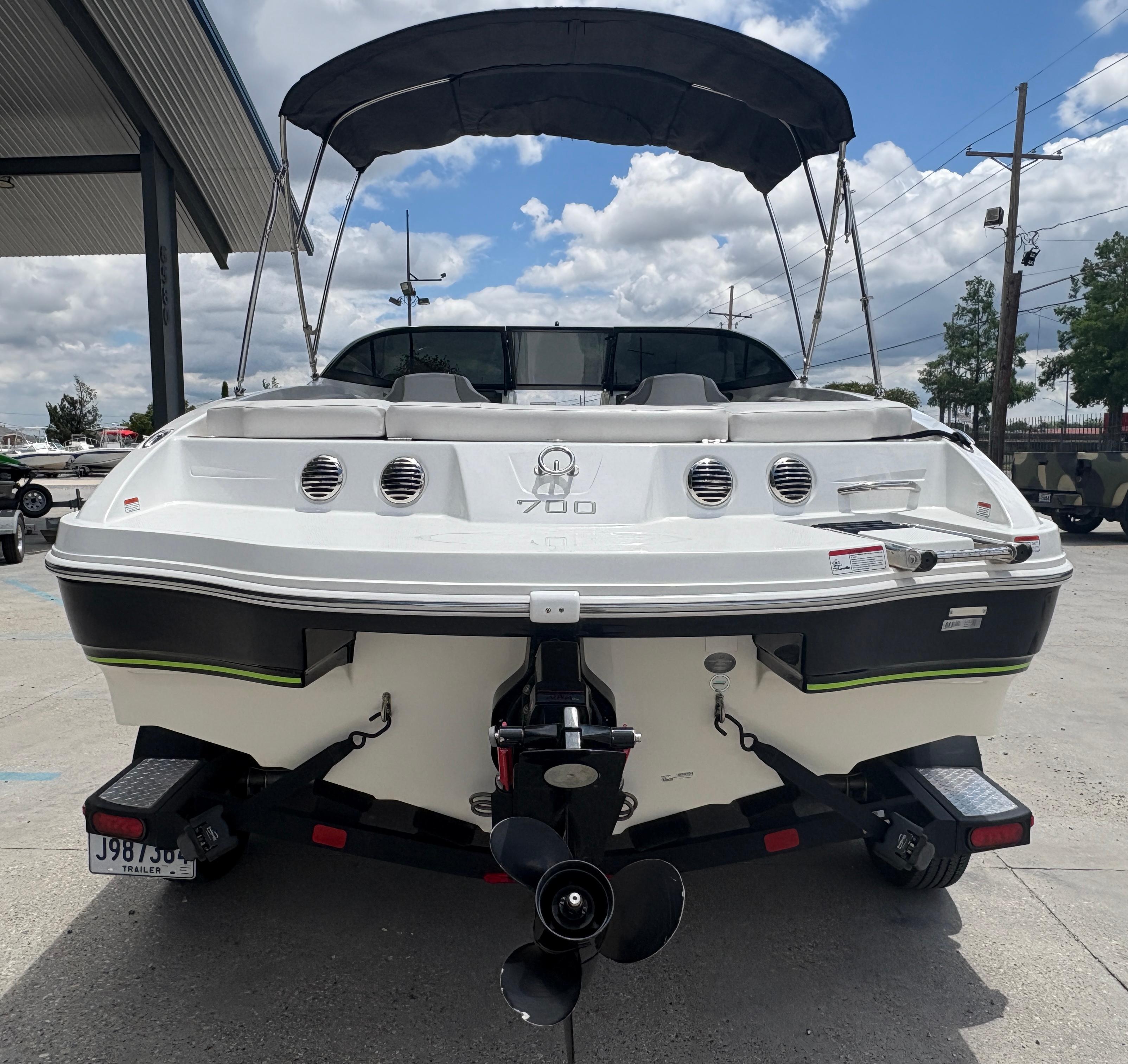 2019 Tahoe 700 boat with canopy, rear view, parked outdoors under cloudy sky.