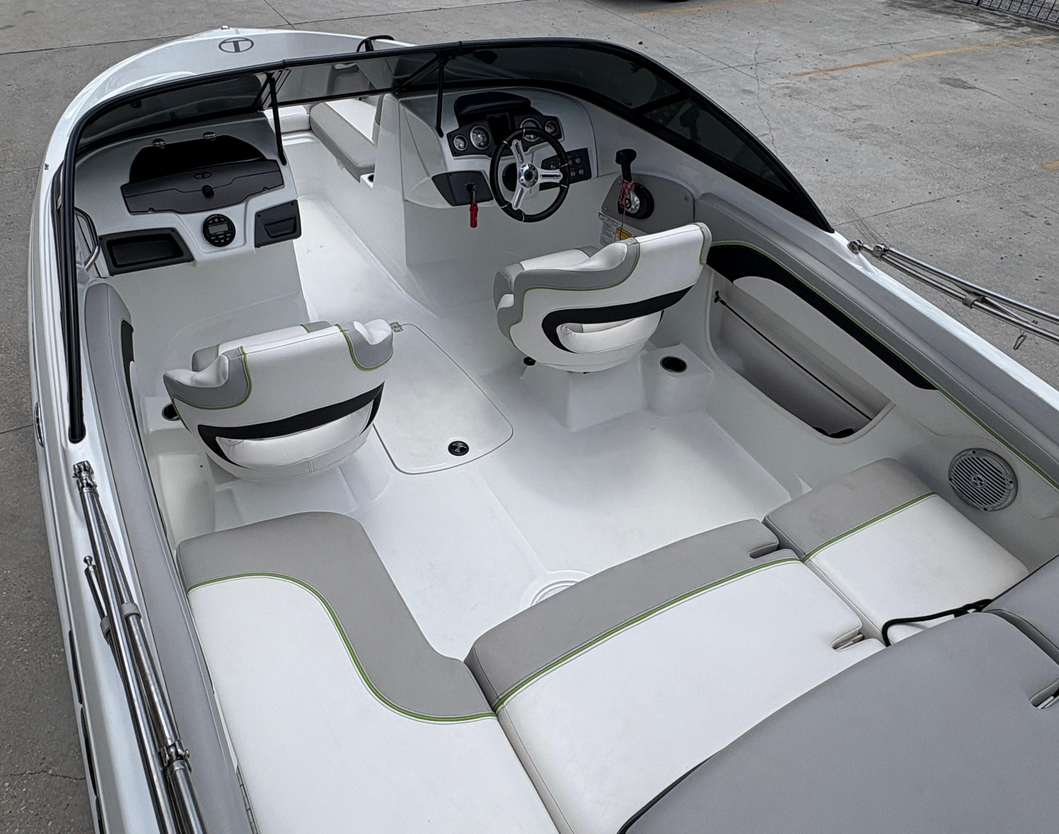 2019 Tahoe 700 boat interior with white and gray seating, steering wheel, and dashboard.