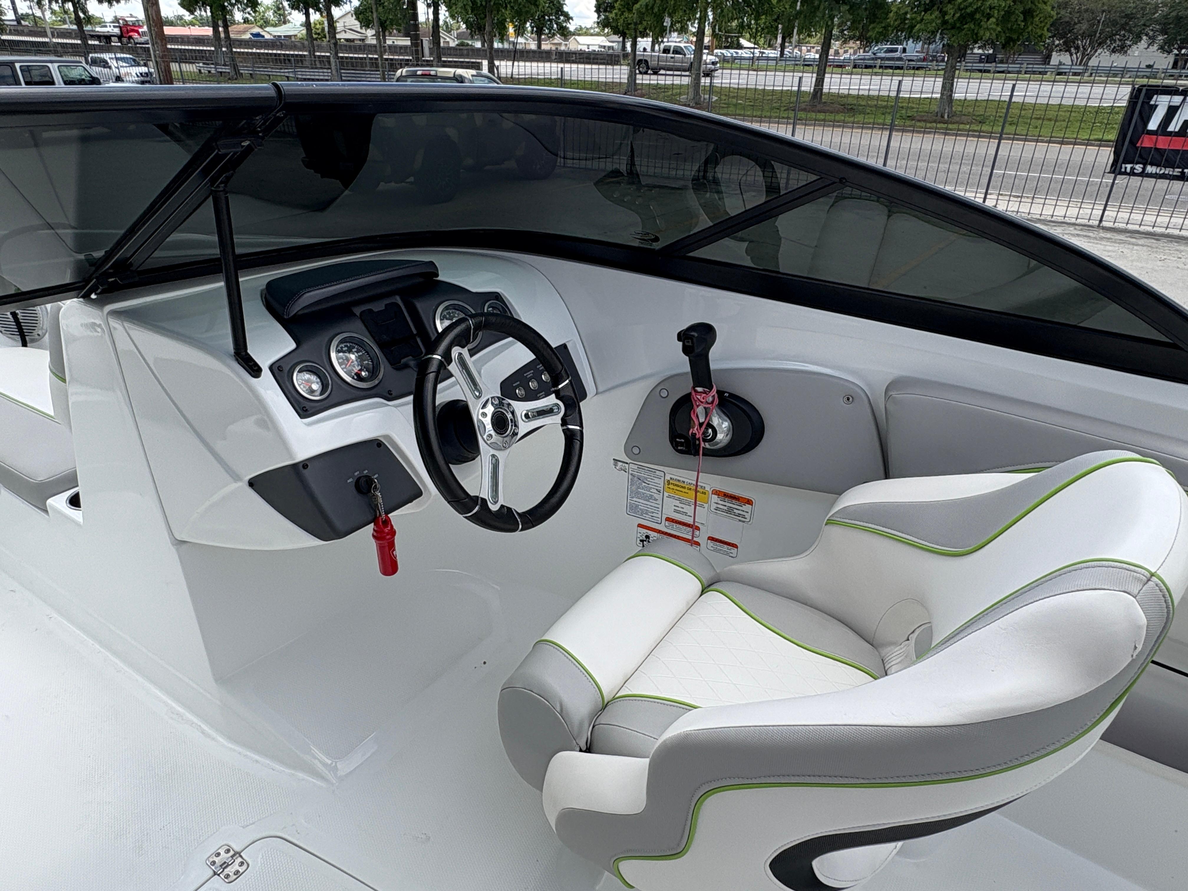 2019 Tahoe 700 boat cockpit with steering wheel and white cushioned seat.
