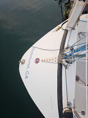 Sailboat stern with "Richmond, CA" text, Schock NY 36, 1984 model, docked in calm water.