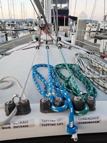 Sailboat deck with colorful ropes, Schock NY 36, 1984, docked at marina.