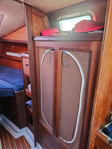 Interior of 1984 Schock NY 36 sailboat with wooden cabinetry and cozy sleeping area.