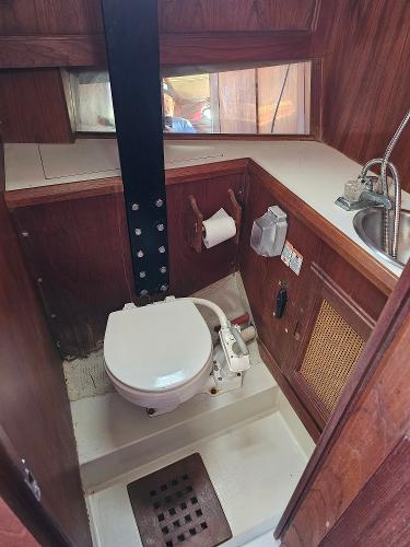 1984 Schock NY 36 boat bathroom with toilet, sink, and wooden interior.