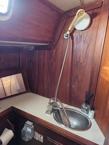 1984 Schock NY 36 yacht bathroom with wooden interior and stainless steel sink.