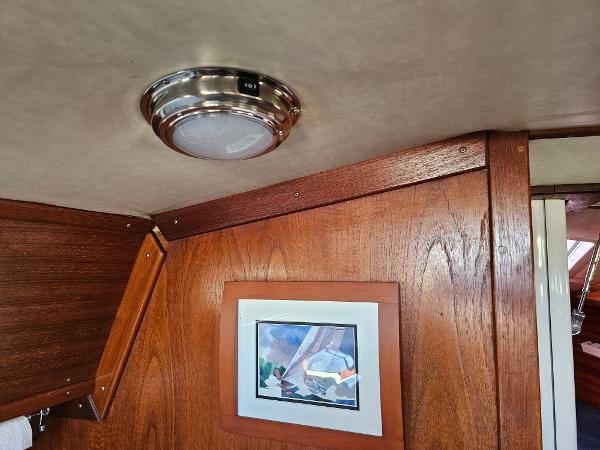 Interior of 1984 Schock NY 36 yacht with wood paneling and framed artwork.