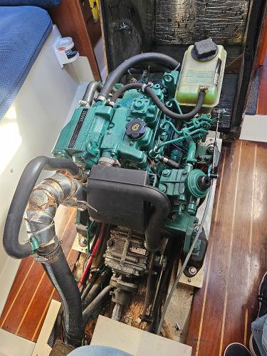 Engine of a 1984 Schock NY 36 sailboat, showcasing detailed components and wooden flooring.