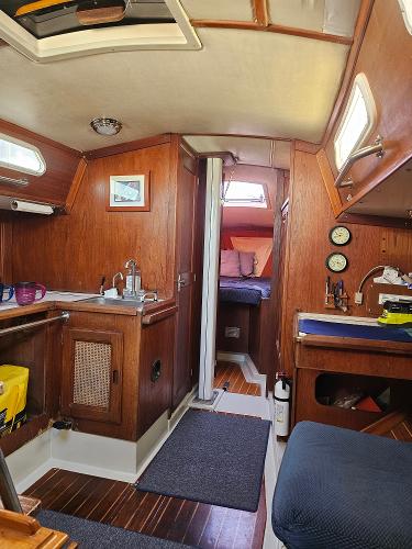 Interior of 1984 Schock NY 36 sailboat, featuring wood paneling and compact living space.