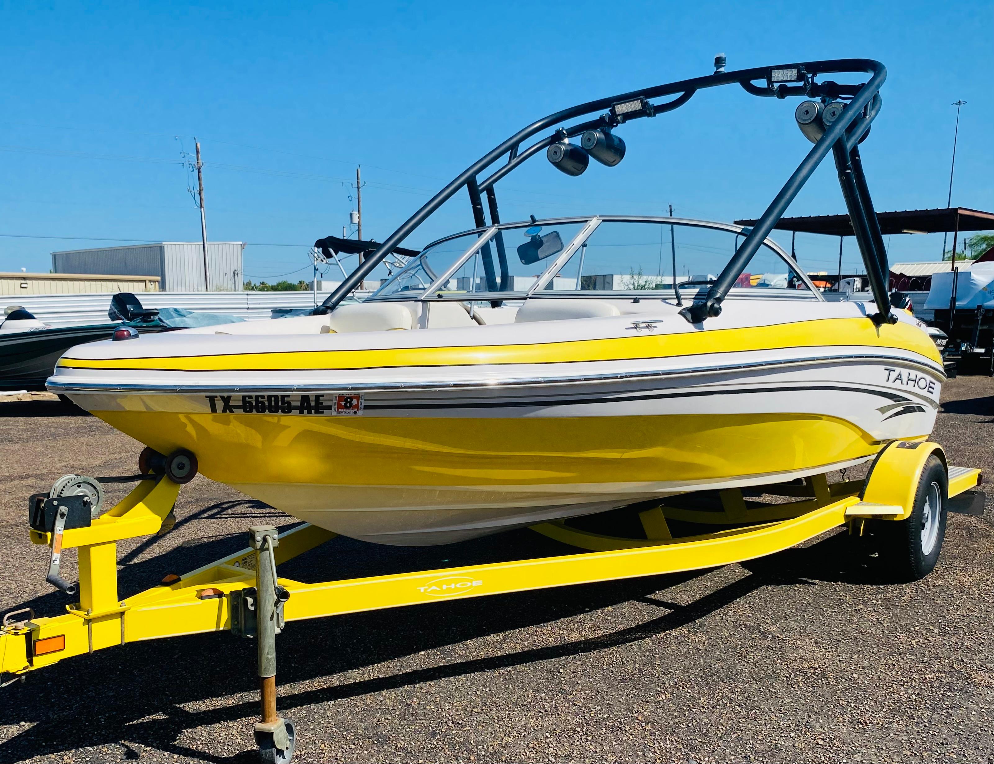 2006 Tahoe Q4 Sport boat in yellow on trailer, parked outdoors.