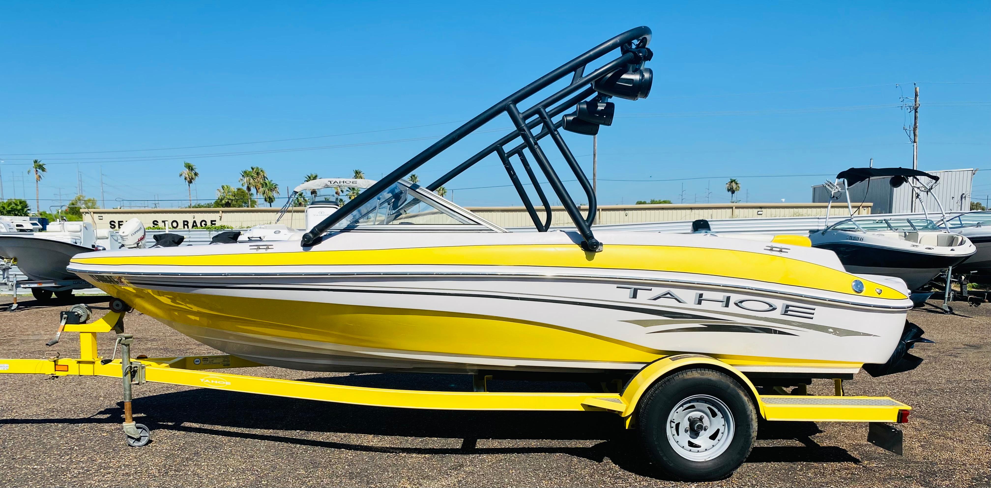 2006 Tahoe Q4 Sport boat in yellow and white on a trailer, parked outdoors.