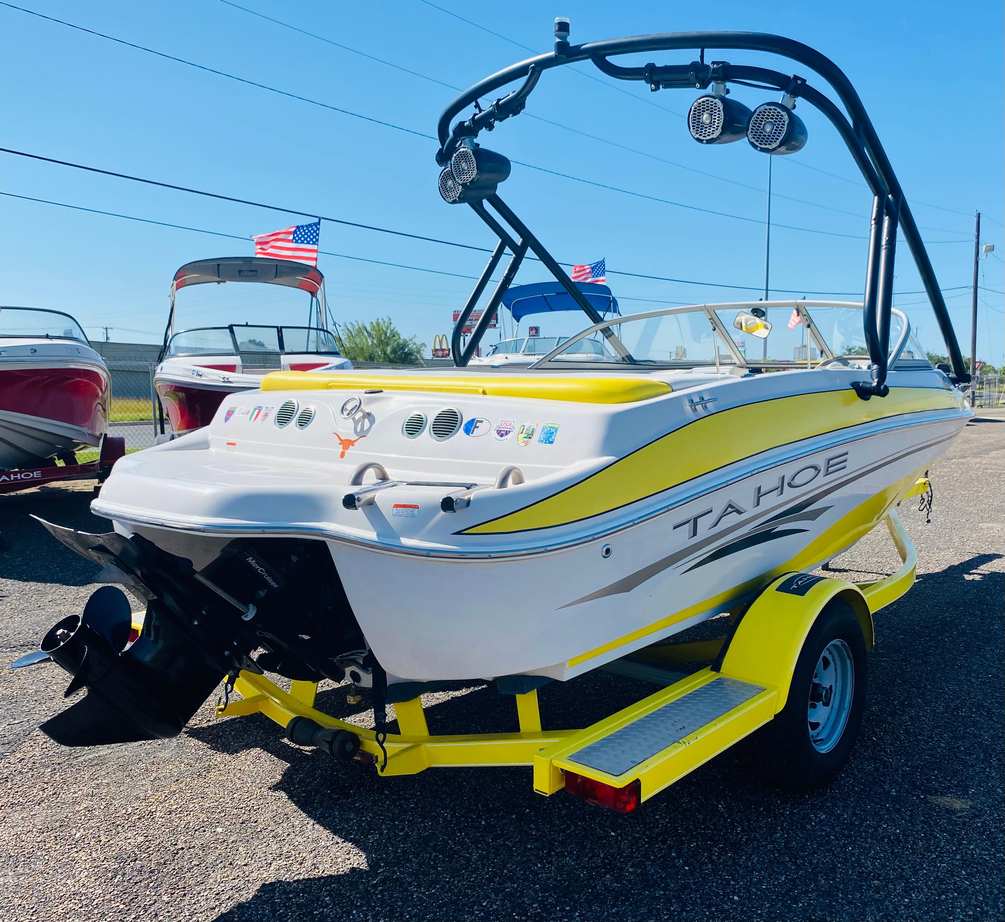 2006 Tahoe Q4 Sport boat with yellow accents on a trailer, displayed outdoors.