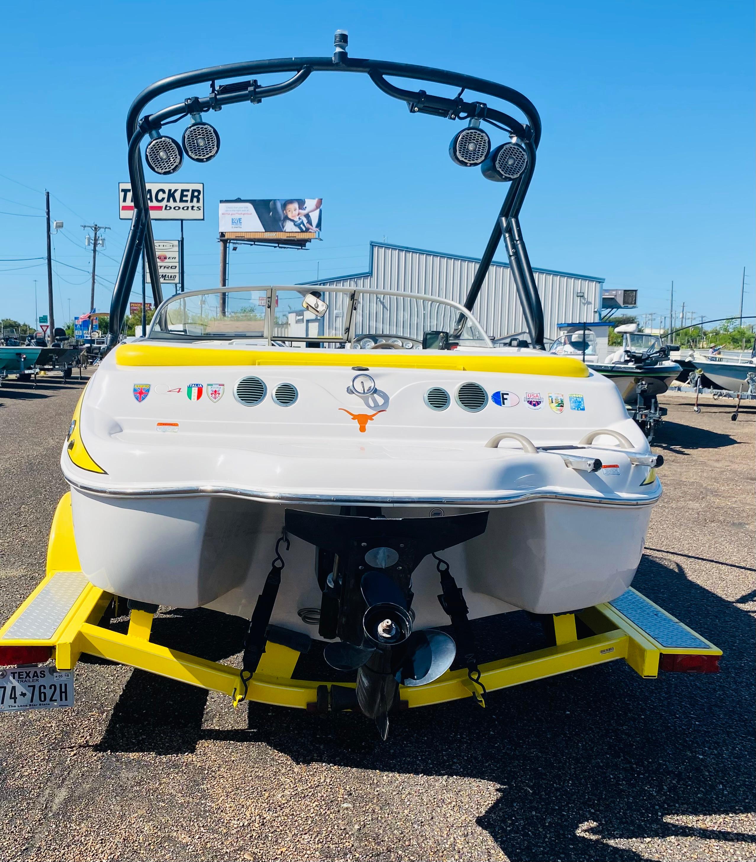 2006 Tahoe Q4 Sport boat on trailer, rear view, sunny day.