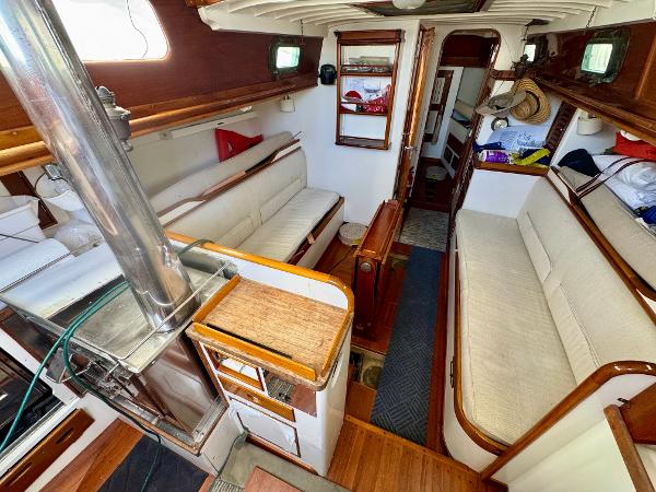 Interior of a 1956 Aage Nielsen 50' Yawl, featuring cozy seating and wooden accents.