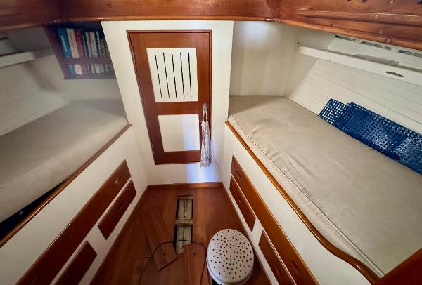 Cozy cabin interior of 1956 Aage Nielsen 50' Yawl with wooden finishes and bunks.